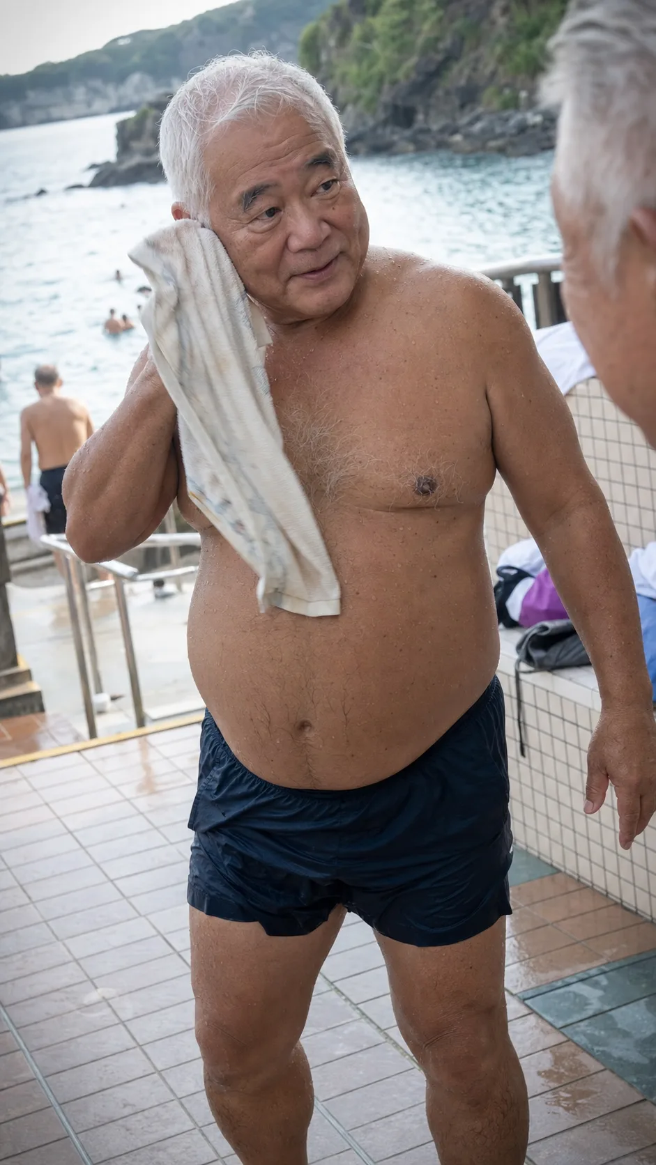 A gent towelling off after a seaside swim in Japan